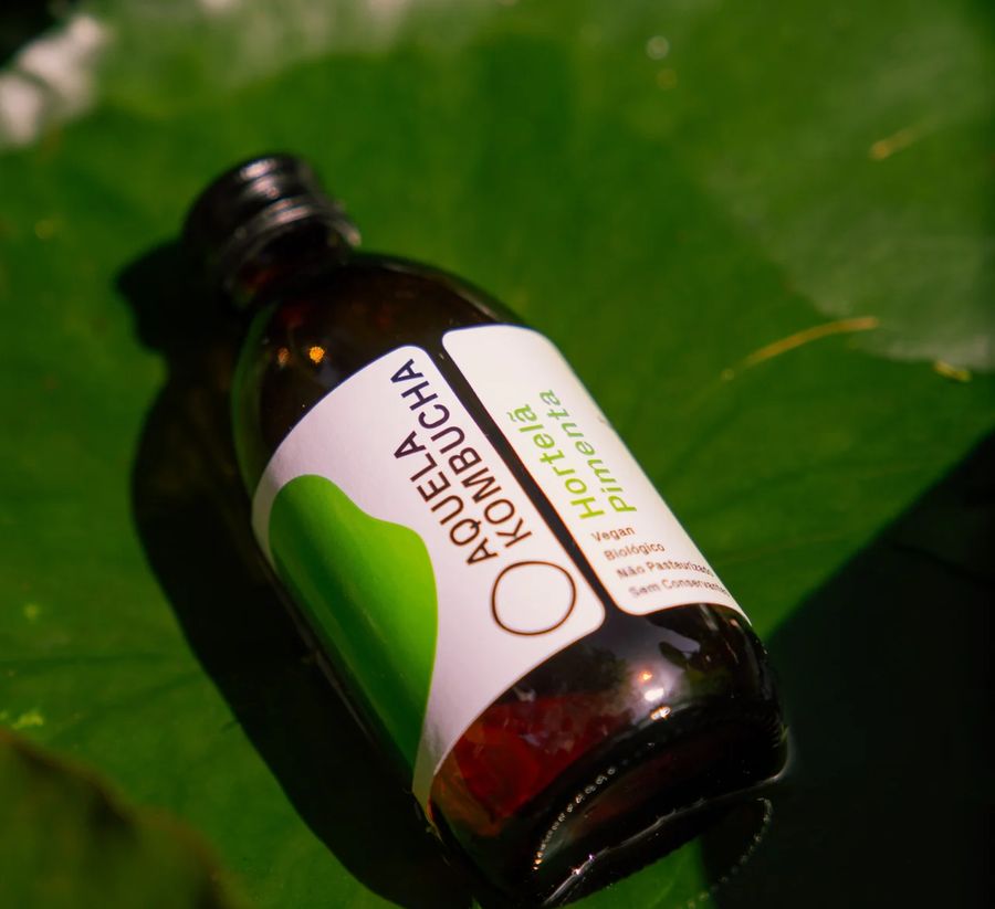 Garrafa Aquela Kombucha Hortelã-Pimenta pousada numa folha grande