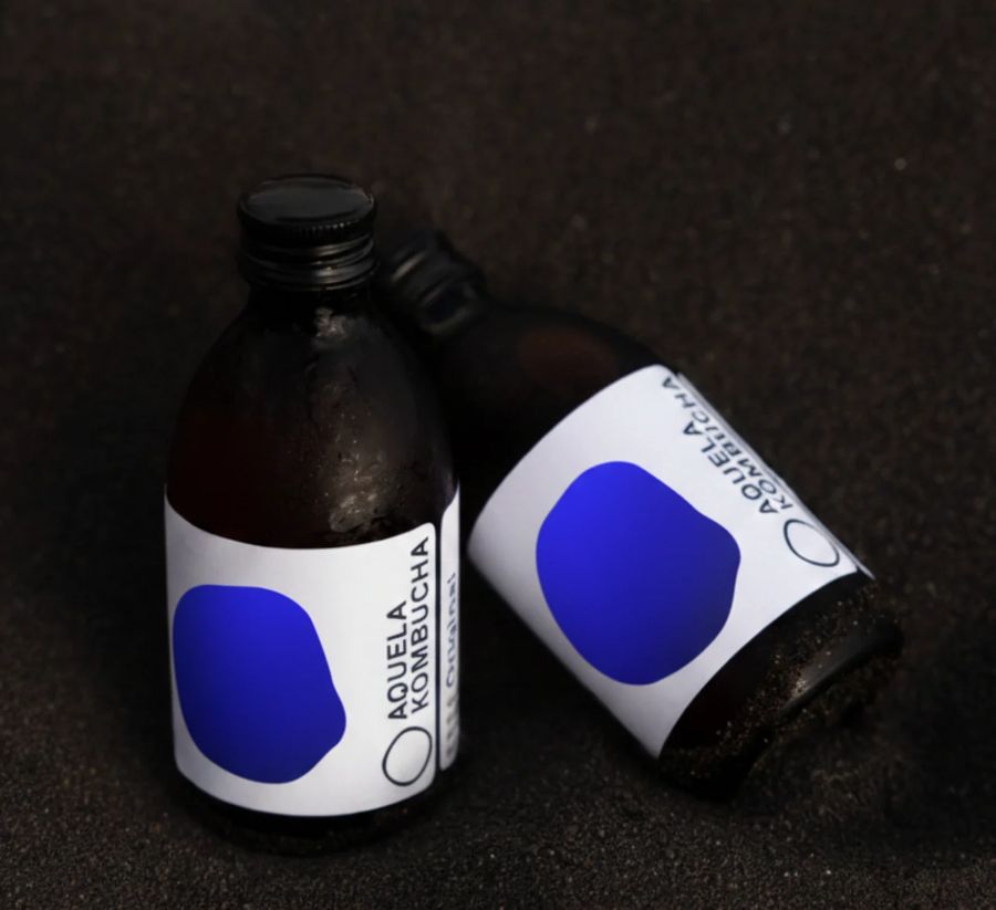 Duas garrafas Aquela Kombucha Original sobre fundo escuro